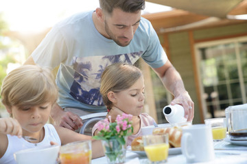 Obraz na płótnie Canvas Family having breakfast in summer morning