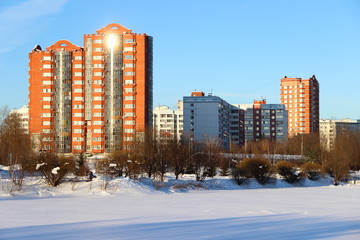 Obraz premium Russia, Moscow region, Mytishchi. Beautiful winter in the city Park - frozen lake under the snow on the background of modern high-rise buildings and blue clear sky on a sunny winter day