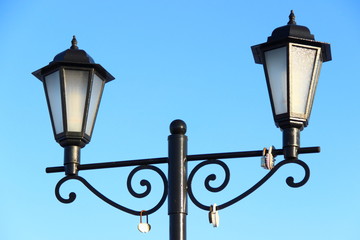 Street lamp on blue sky background - Beautiful old forged lantern with two faceted lamps