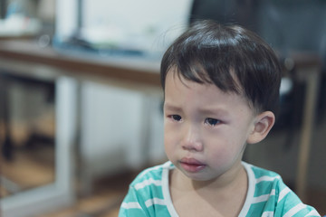 A sad boy is crying, he doesn't want to go to bed at night.
