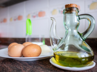 Bottle of olive oil and eggs in plate with salt shaker on background. Natural life concept