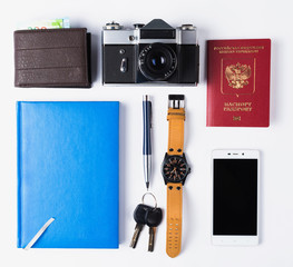 Travel equipment isolated. Phone, watches, keys, notebook, passport, photo camera, purse on white...