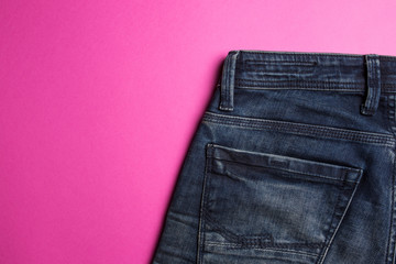 Blue jeans on a pink background closeup