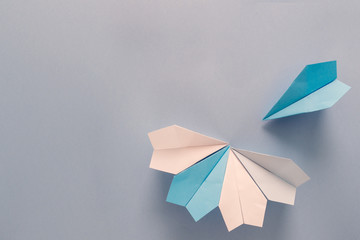 Paper planes placed in a form of unfinished flower over the blue background. Back to school and education concept. Plane as symbol of travelling and tourism.