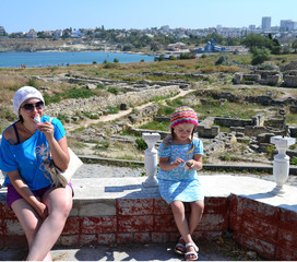 portrait of a girl in a blue summer dress eating ice cream and a woman 