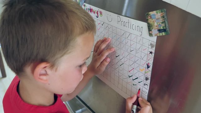 A Little Boy Marks Off Another Day On Happy Practicing Chart