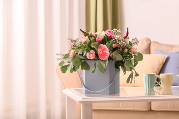 Fototapeta premium Gift box with beautiful flowers on table indoors