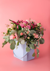 Gift box with beautiful flowers on color background