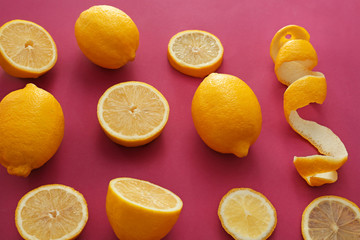 Fresh ripe lemons with slices on color background