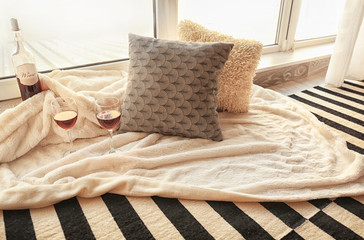 Cozy place for rest with soft pillows and wine near window