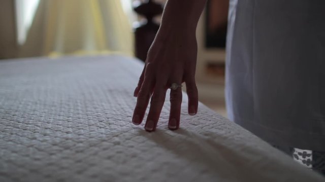 Close up of hand caressing bed towards dress.mov