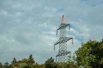 A huge power pole with sky and clouds in the background
