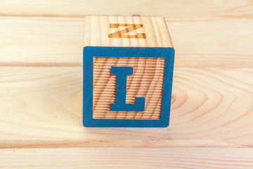wooden block alphabet lay on wooden floor