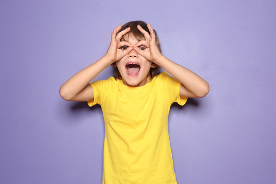 Funny little boy in t-shirt on color background