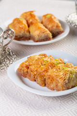 A piece of baklawa on a  plate on a  table, top view, baklava, feast treat ramadan traditional dessert