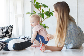 Child is offended by his mother. Little sad baby boy turned away from his mom, keeps her insulted...