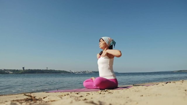 Old retired woman doing some yoga on the beach super slow motion
