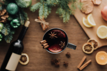 top view of cup of homemade mulled wine with cinnamon sticks on wooden tabletop, christmas concept