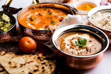 Indian Lunch / Dinner main course food in group includes Paneer Butter Masala, Dal Makhani, Palak Paneer, Roti, Rice etc, Selective focus