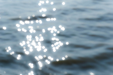 Blurry background of sea water surface and bokeh of sun light reflection.