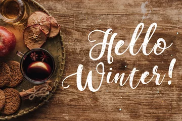 Küchenrückwand glas motiv top view of mulled wine in cup and greeting Hello Winter on table, christmas concept © LIGHTFIELD STUDIOS
