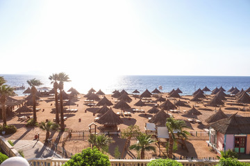 View of beach with comfortable sun loungers at resort