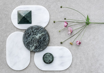 Composition with Japanese anemone and various marble shapes.
