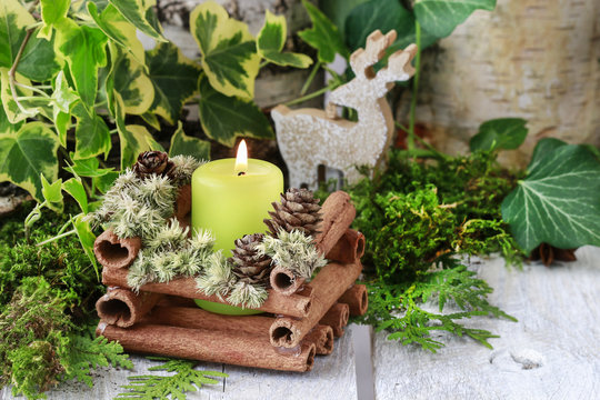 Candle holder made of cinnamon sticks and moss.