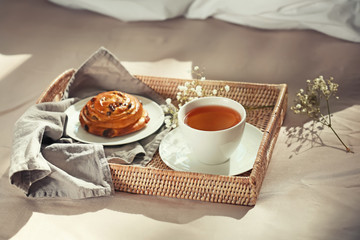 Wicker tray with delicious breakfast on bed