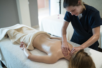 Obraz na płótnie Canvas Therapist massaging patient at wellness spa