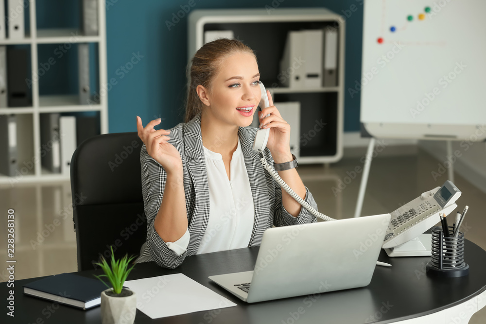 Wall mural beautiful female secretary talking on telephone in office