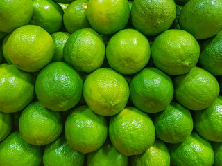 Closeup of fresh limes in a stack at the fruit market