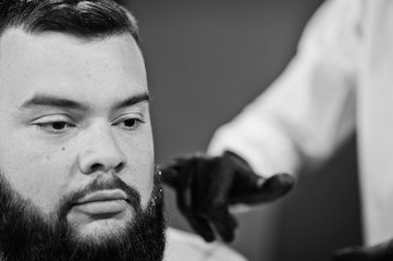 Handsome bearded man at the barbershop, barber at work.
