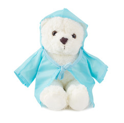  White fluffy cute teddy bear wearing blue rain coat and sitting on white background.