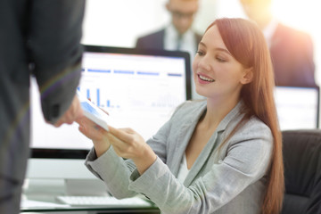 Obraz premium young beautiful woman examines graphics sitting at her workplace