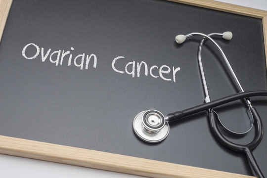 Ovarian Cancer written in chalk on a blackboard black next to a stethoscope, conceptual image