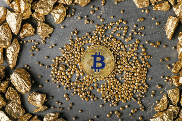 Gold nuggets and bitcoin on grey background