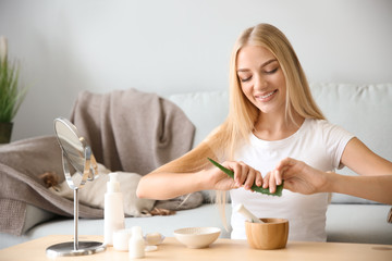 Young woman making healthy facial mask with aloe vera extract at home