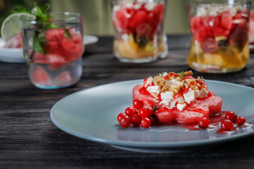 Plate with delicious watermelon salad on wooden table, closeup