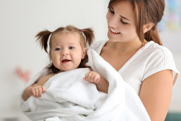 Young mother with cute little baby at home