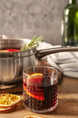 Glass of delicious mulled wine on wooden table