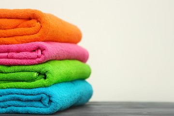 Obraz na płótnie Canvas Stack of bright color towels on table against light background