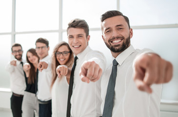 business team standing in new office and pointing forward