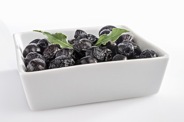 olive nere tostate in ciotola bianca con alloro