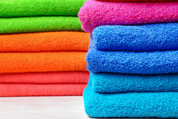 Stacks of soft color towels on table, closeup