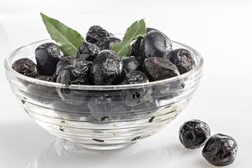 olive nere tostate in coppa di vetro trasparente con alloro