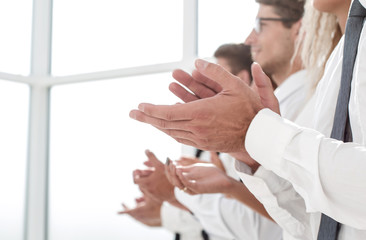 business team applauds standing in a bright office