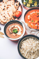Indian Lunch / Dinner main course food in group includes Paneer Butter Masala, Dal Makhani, Palak Paneer, Roti, Rice etc, Selective focus