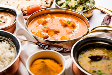 Indian Lunch / Dinner main course food in group includes Paneer Butter Masala, Dal Makhani, Palak Paneer, Roti, Rice etc, Selective focus