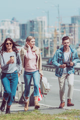 young man and women walking on street while traveling together